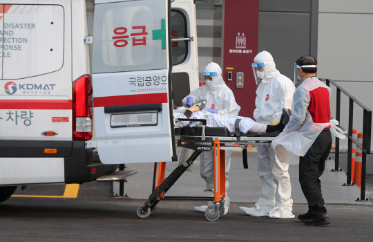 21일 오후 서울 국립중앙의료원 음압 격리병동에서 의료진이 응급환자를 이송하고 있다.  연합뉴스